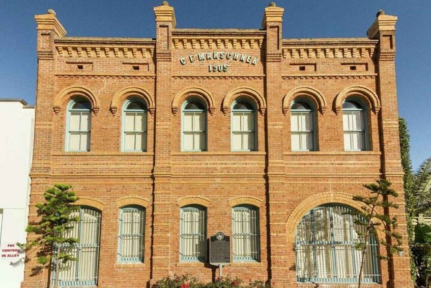 A brick building with arched windows and a plaque reading 'GEMARSCHNER 1905'. 3