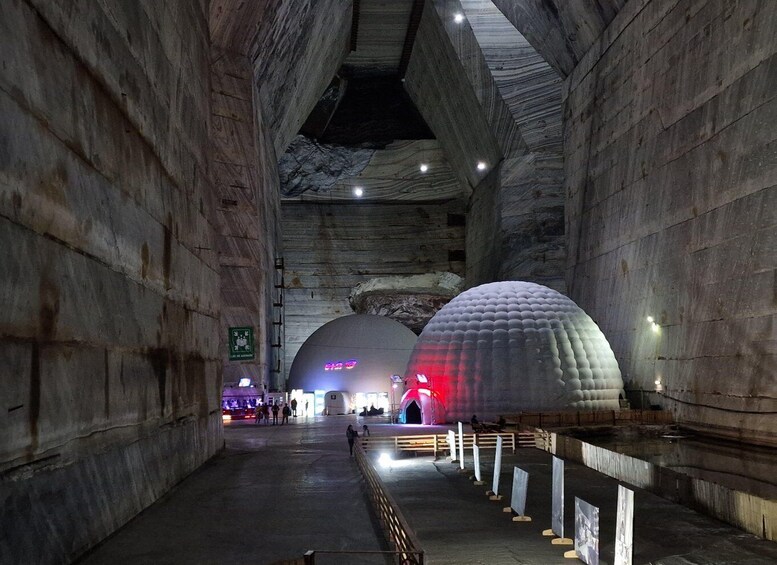 Una extensa caverna subterránea con paredes de piedra y un pasillo central. 1
