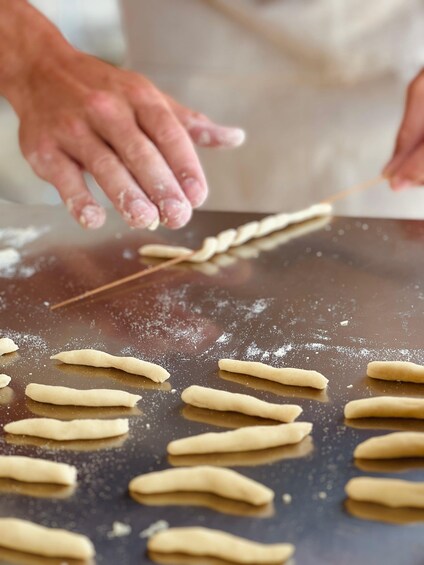 Hands shaping dough on a floured surface. 5