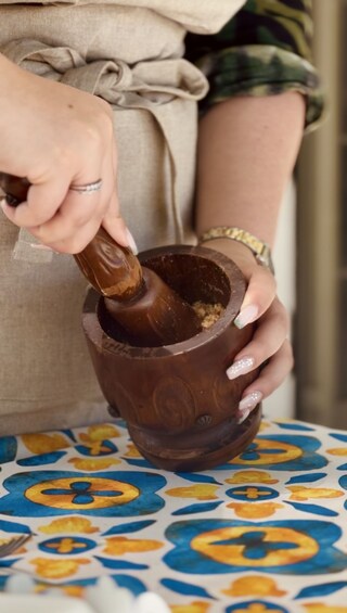 A person using a wooden mortar and pestle. 4