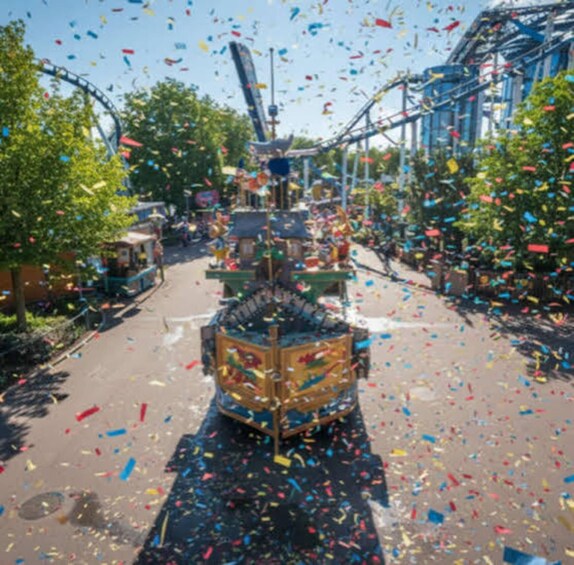 A roller coaster with colorful confetti falling around it. 3