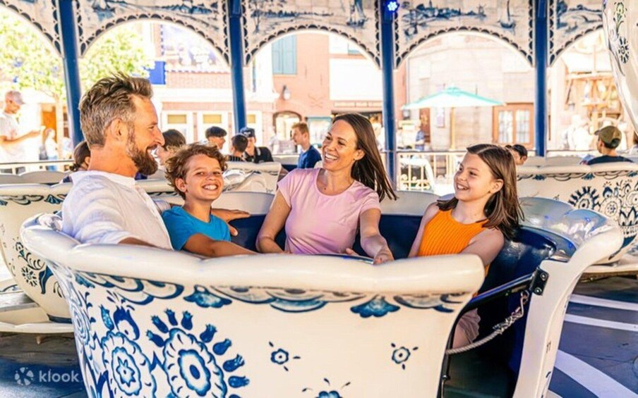 A family enjoying a ride in a decorative boat at a public park. 2
