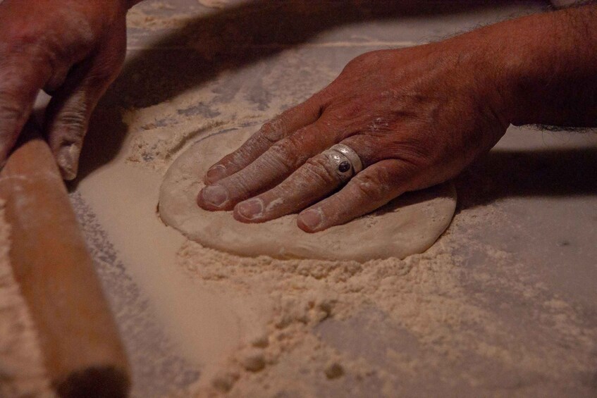 Hands shaping dough on a floured surface. 4