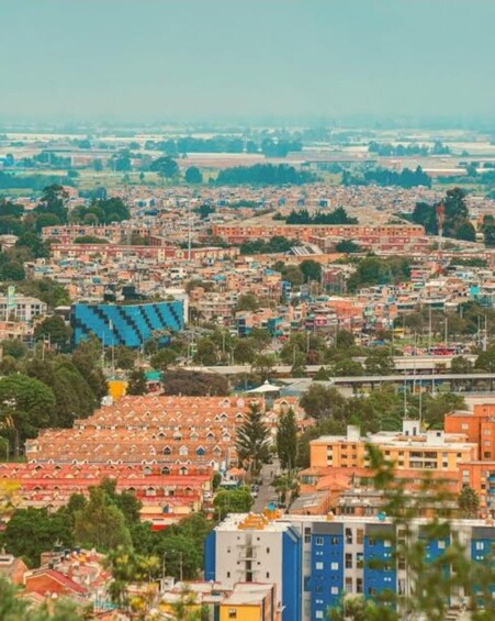 A densely populated urban area with a mix of residential and commercial buildings, including a prominent blue structure. 3