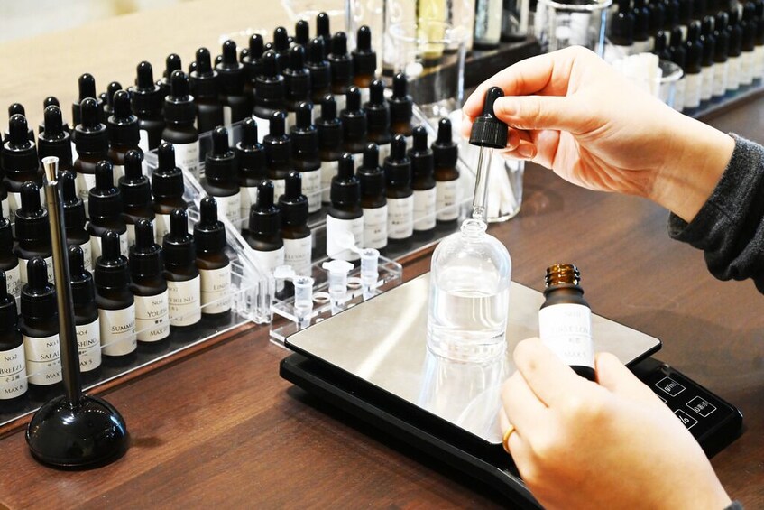 A person using a digital device to interact with a display of various bottles. 5