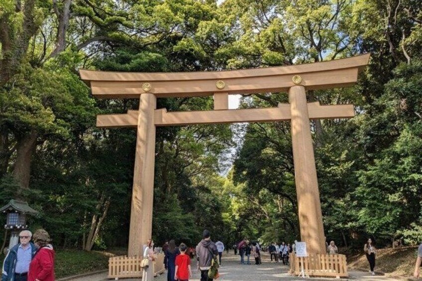 A traditional Japanese torii gate in a forested area with people walking around. 4