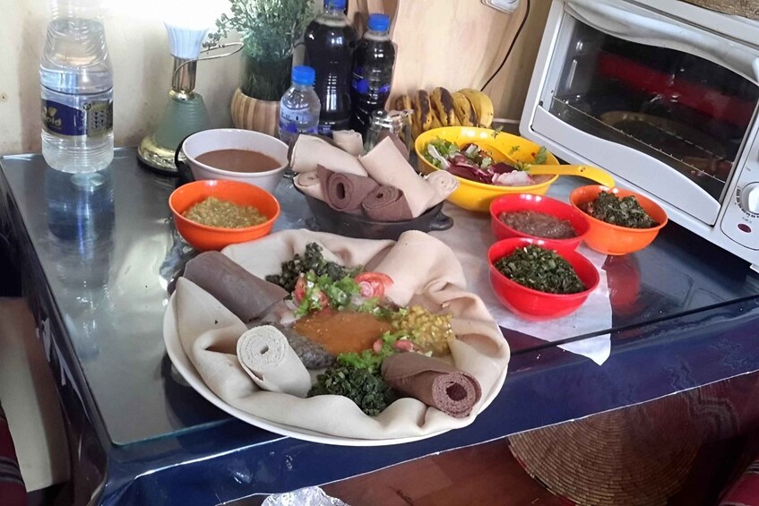 A variety of dishes on a table, including a plate with rolled flatbreads, a bowl of greens, and several small bowls with different sauces. 3