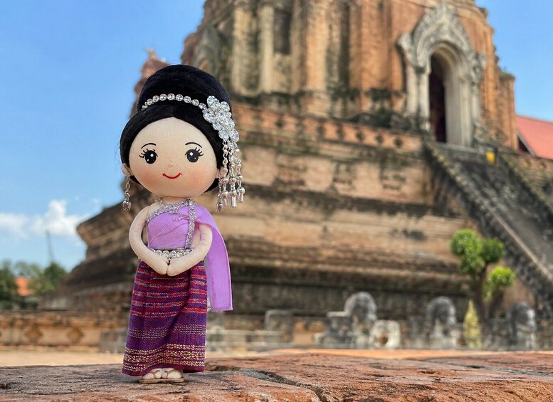 A figurine in traditional attire with a temple in the background. 2