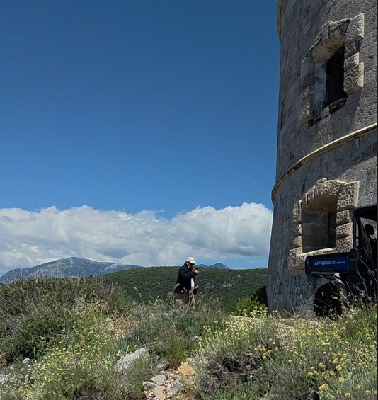 A person standing in a field with a building in the background. 5