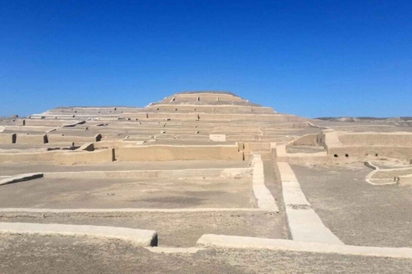 A large stepped pyramid structure in a desert landscape. 3