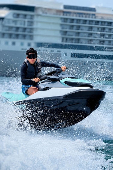A person riding a jet ski on water with a building in the background. 4