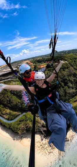 Two people paragliding with a scenic landscape below. 1
