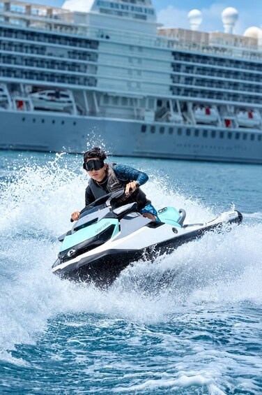 A person jet skiing on water with a cruise ship in the background. 5