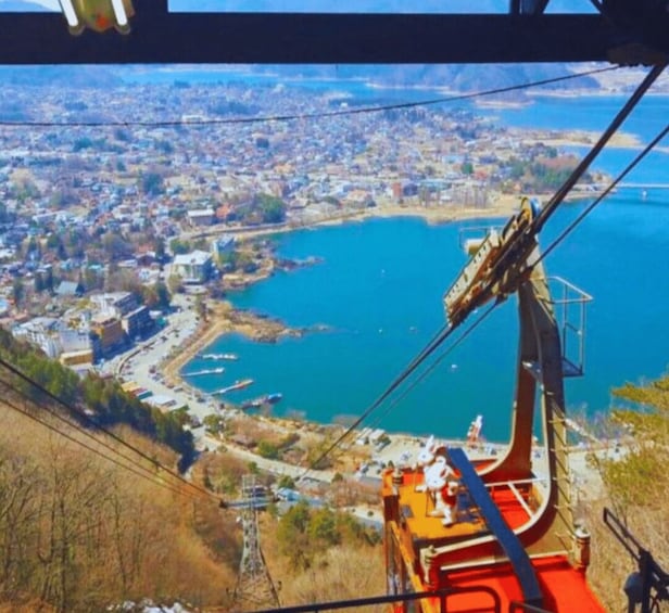 A cable car system with a view of a coastal city and a large body of water. 5