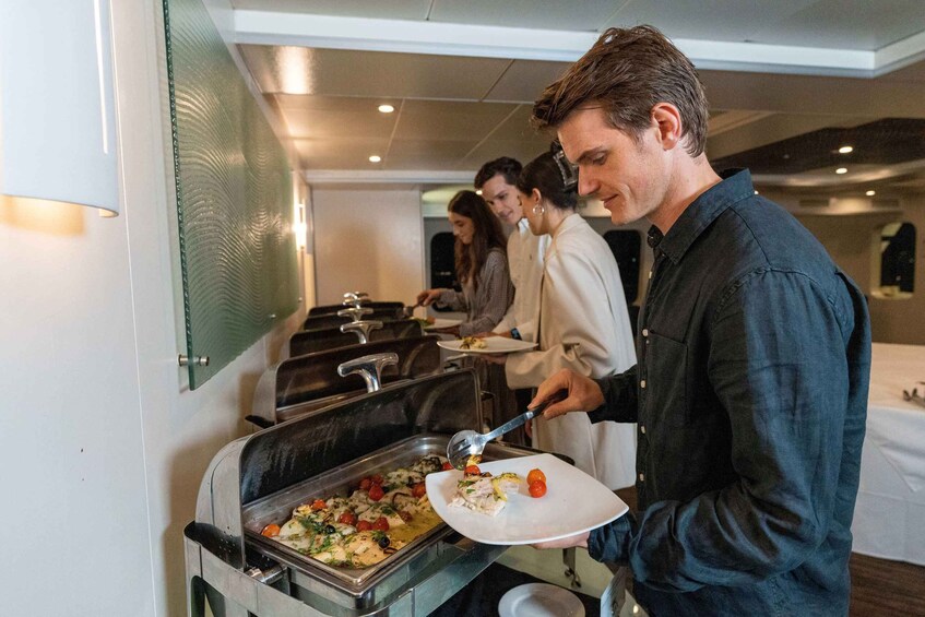 A buffet with a variety of dishes, including a tray with a salad and a plate with a piece of fish. 2