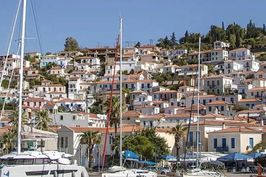 A coastal town with white buildings, red roofs, and a marina with boats. 5