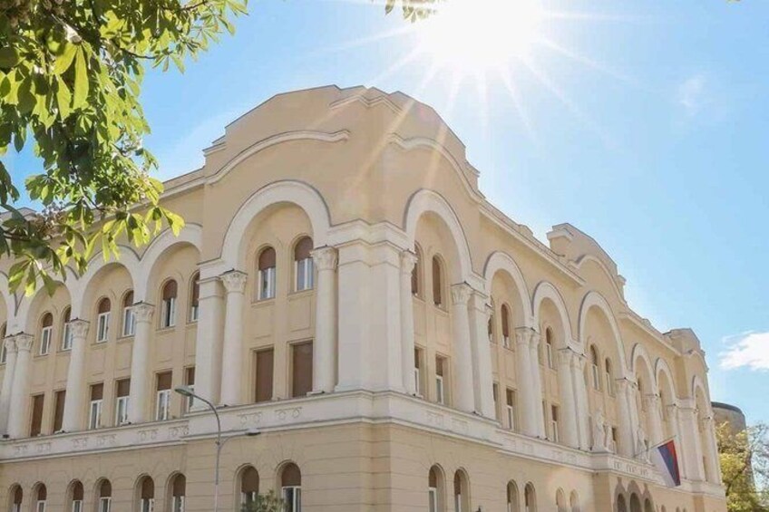 A large, classical building with arched windows and a prominent flag. 3