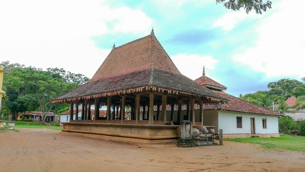 A traditional stupa with a tiled roof and a smaller structure nearby. 2
