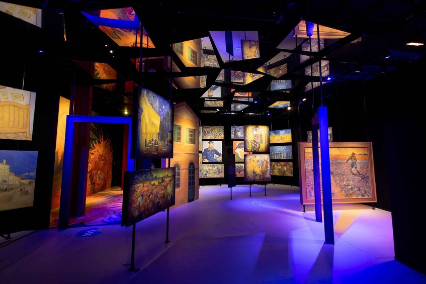 An art gallery with paintings displayed on walls and hanging from the ceiling. 3