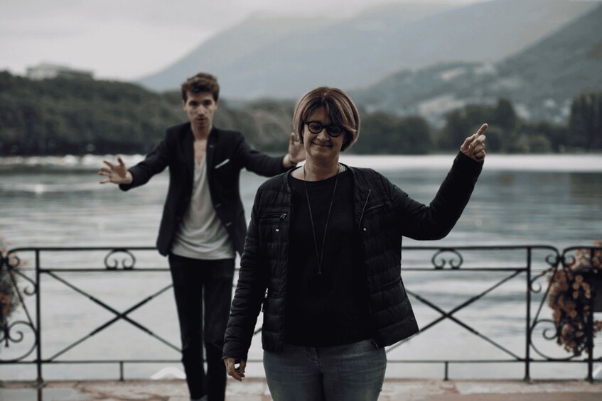 Two people walking by a lake with mountains in the background. 2