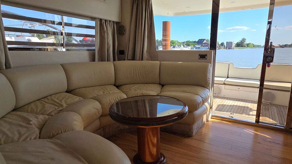 A boat interior with a curved sofa and a small table. 4