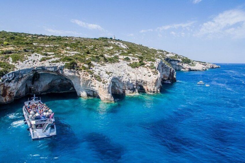 A boat navigating through a narrow sea passage surrounded by rocky cliffs. 3
