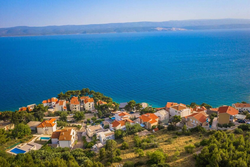 A coastal village with red-roofed houses and a clear blue sea. 4