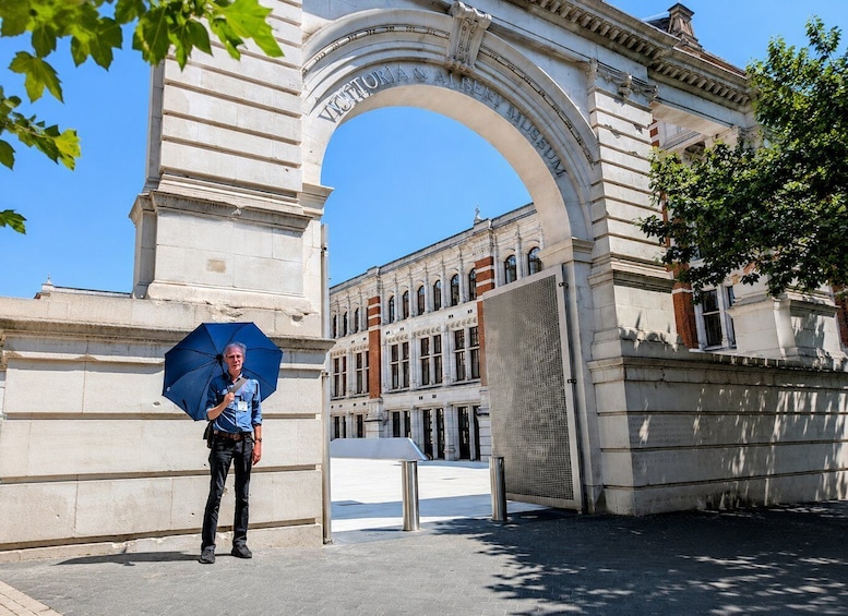 A person standing under an archway with the inscription 'Victoria & Albert Museum' in front of a classical building. 2