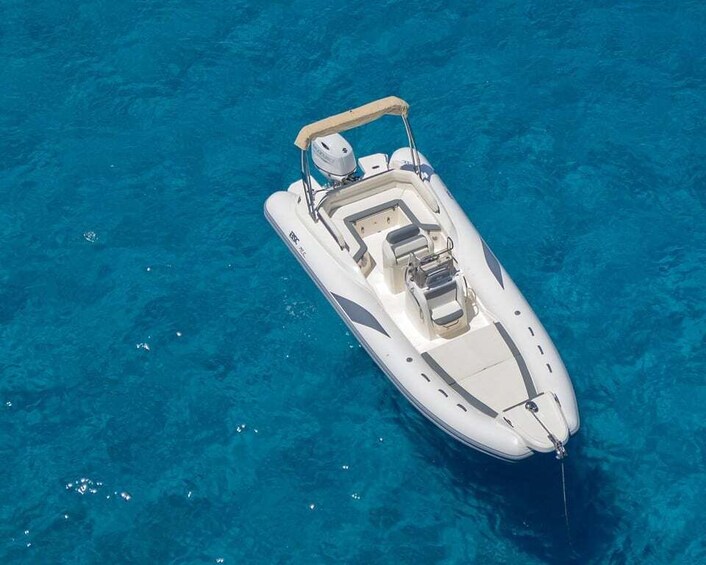 A white motorboat with a canopy on a clear blue sea. 3