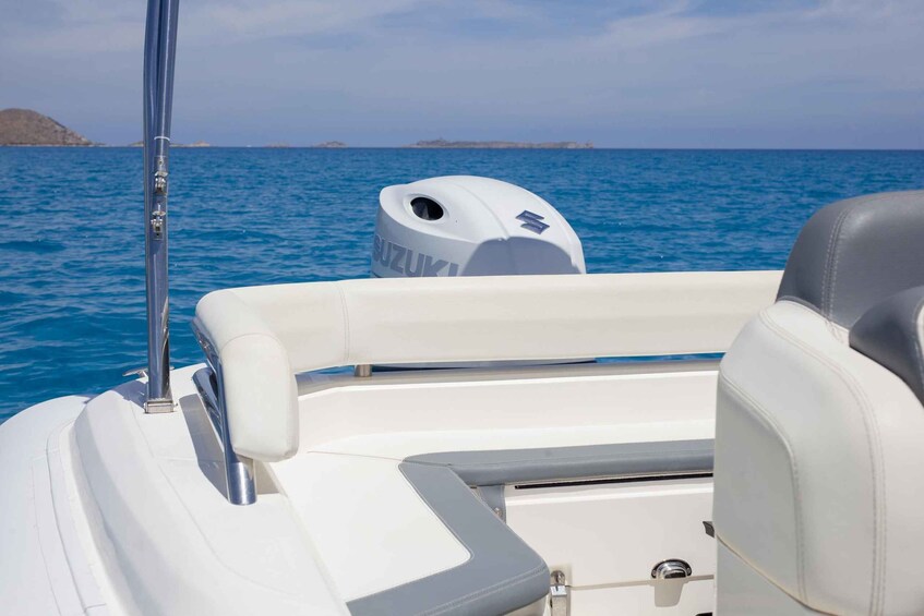 A boat's interior with a Suzuki logo, a metal pole, and a view of the sea and distant land. 2