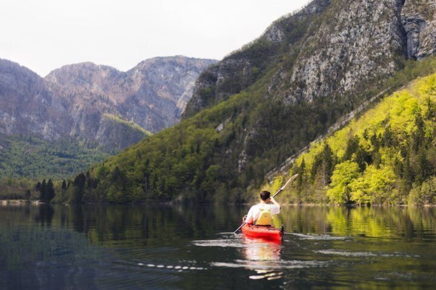 A person kayaking on a calm lake surrounded by mountains. 2