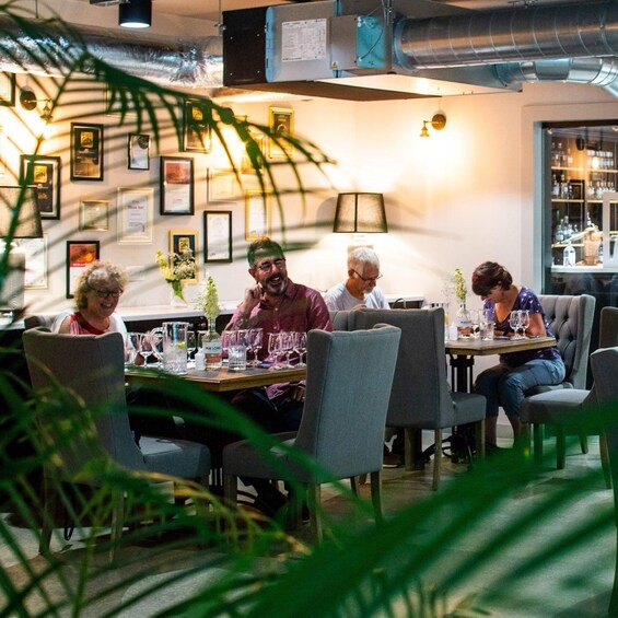 A group of people dining in a restaurant with framed certificates on the wall. 3