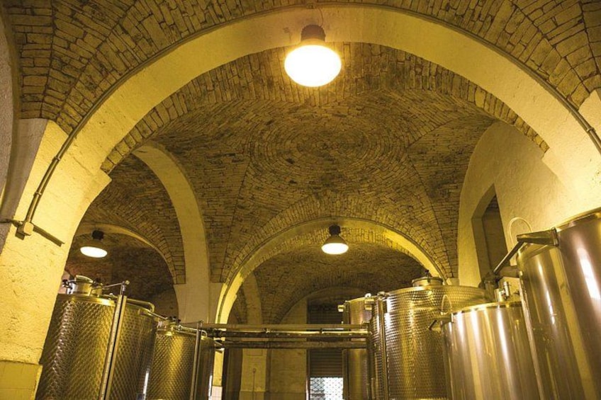 A vaulted ceiling with brick arches and stainless steel tanks. 4