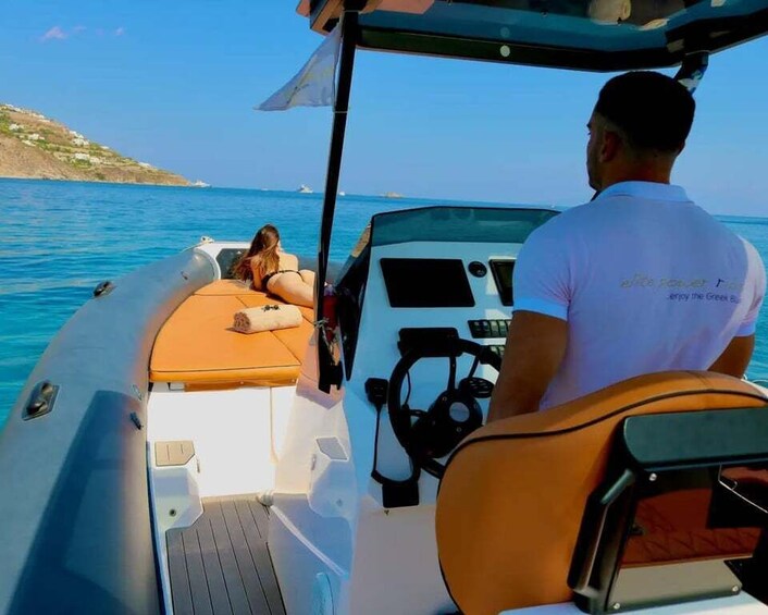 A boat with a person steering and another person relaxing on the deck. 3