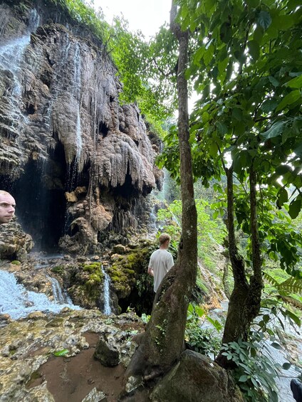 A waterfall cascading down a rocky cliff surrounded by lush greenery. 4