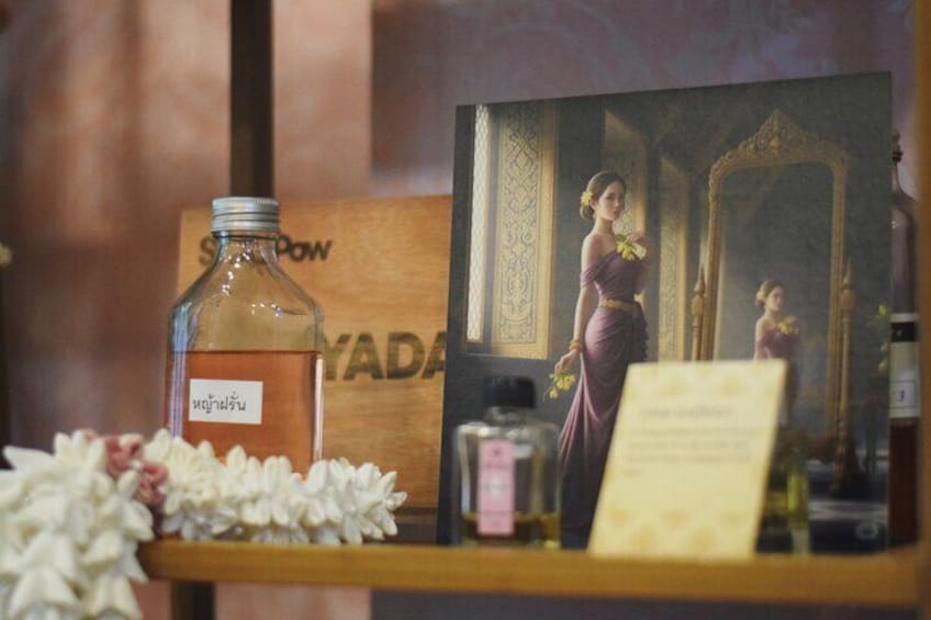 A bottle labeled 'Sawasdee' and a framed picture of a woman in a purple dress. 1