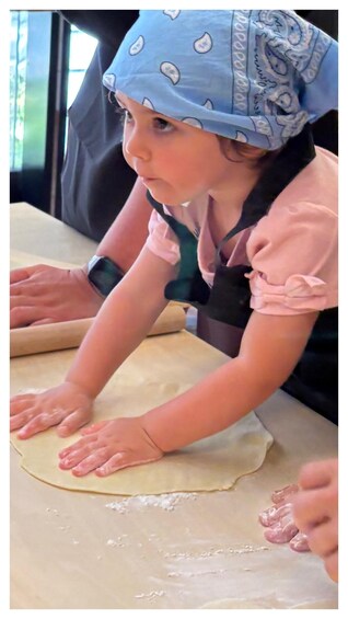 A child rolling out dough on a table. 2