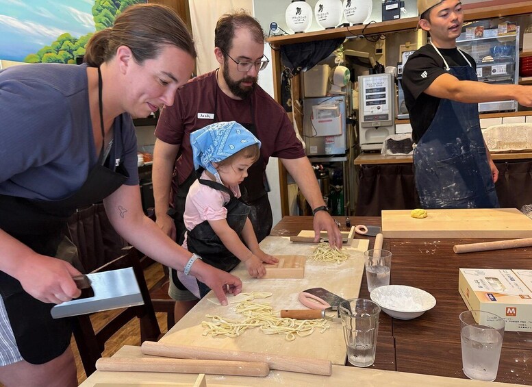 People preparing food, specifically pasta, in a kitchen setting. 4