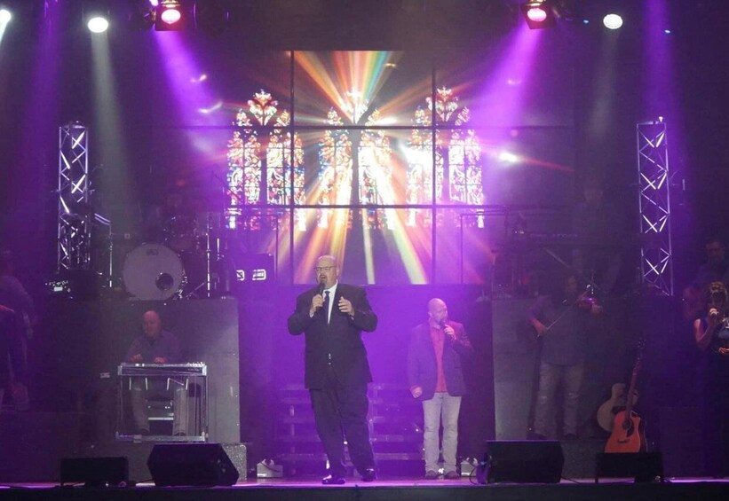 A stage with a performer, a keyboard, and a guitar. 1