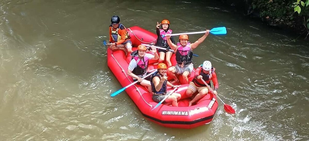 A group of people in a red inflatable raft on a river. 4