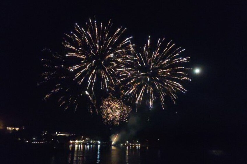 Fireworks over a body of water with reflections. 3
