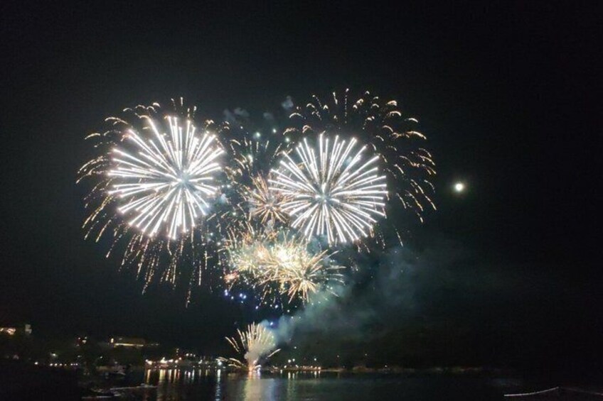 Fireworks over a body of water at night. 4