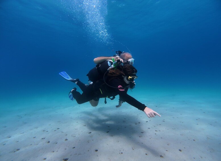 A diver underwater with fins and a backpack. 3