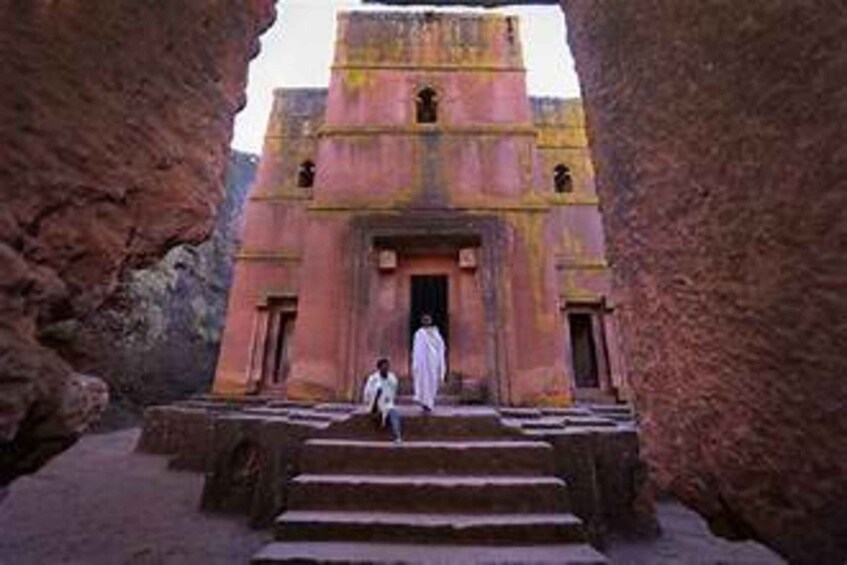 A temple with a central doorway, flanked by two smaller structures, set within a rocky canyon. 4