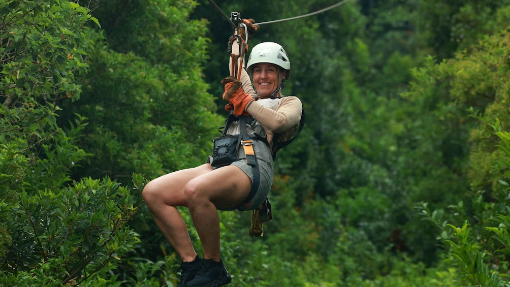 A person zip-lining through a forest. 1