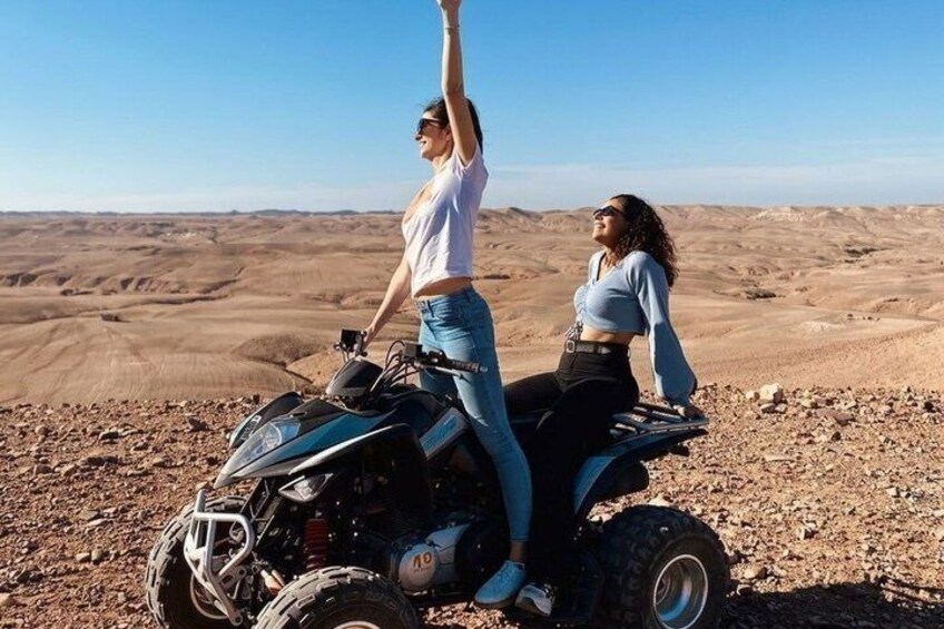 Two people on an all-terrain vehicle in a desert landscape. 1