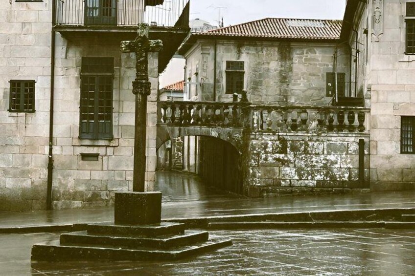 A historic stone building with a water fountain, a bridge, and a gate. 5