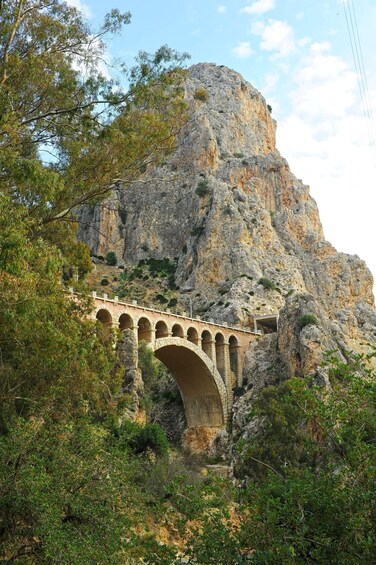 A stone bridge with arches spanning a rocky gorge. 2