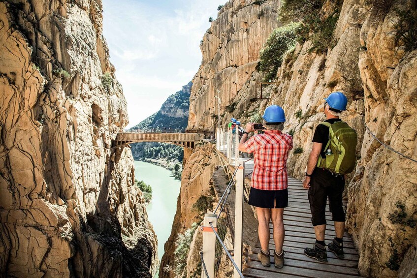 A wooden bridge over a canyon with a river below. 5