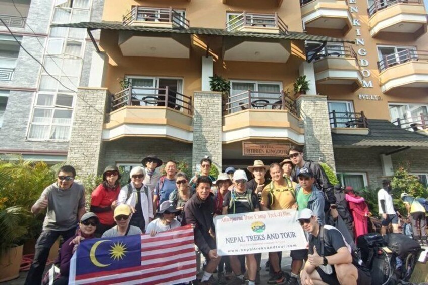 A group of people in front of a building with balconies and a sign that reads 'Hidden Kingdom.' 4